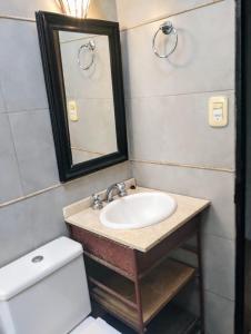 a bathroom with a sink and a toilet and a mirror at CASA del PEZ céntrica para 5 huespedes in La Plata