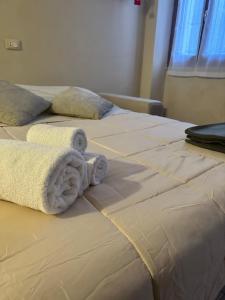 two beds with towels on them in a bedroom at Nocciolino Home in Suzzara