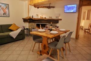 a table and chairs in a living room with a fireplace at Pancino's House in Valtournenche