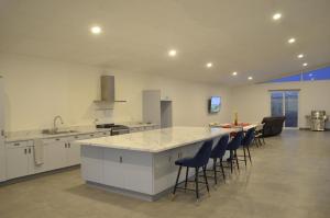 a large kitchen with a counter and chairs in it at CASA LUGO mx in El Porvenir