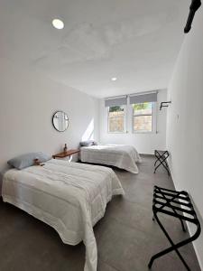two beds in a room with white walls at CASA LUGO mx in El Porvenir