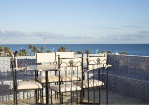 a group of chairs and a table on a balcony overlooking the ocean at Dar Sonia in Hammamet