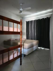 a bedroom with a bed and two bunk beds at Apartamento 2 quartos em Torres-RS in Torres