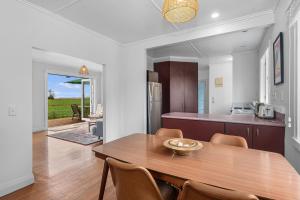 una cucina e una sala da pranzo con tavolo e sedie in legno di Serene Cove Escape - Waipu Holiday Home a Waipu Altre 14 foto
