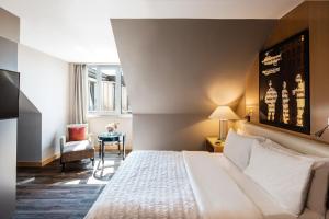 a hotel room with a bed and a chair at Le Meridien Munich in Munich