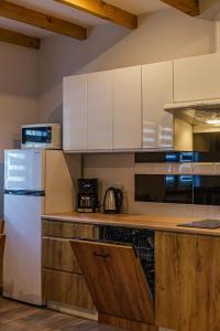 a kitchen with white cabinets and a white refrigerator at Apartamenty Koło Brzegu in Gąski +80 photos
