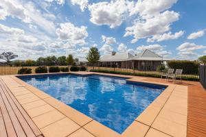 una piscina en un patio con una casa en Owl Head Lodge, en Gulgong