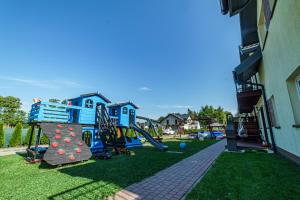 a playground with a slide in a yard at Apartamenty Koło Brzegu in Gąski