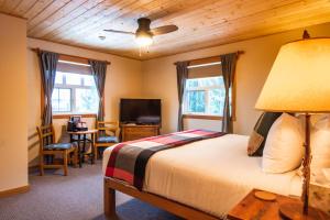 レベルストークにあるCourthouse Inn Revelstokeのベッドルーム1室(ベッド1台、テーブル、椅子付)