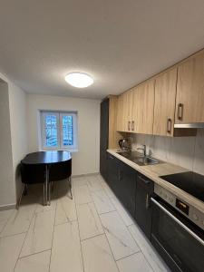 a kitchen with a black table and a sink at Skiing & Snowboard Apartment Accessible by Public Transport in Küblis