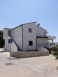 a white house with a stone wall and stairs at Apartments Mara Mandre in Mandre