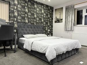 Schlafzimmer mit einem Bett und einer Wand mit Fotografien in der Unterkunft Mizz place in Manchester