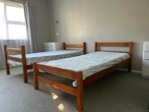 una camera da letto con due letti e una finestra di Vale Whangārei a Whangarei