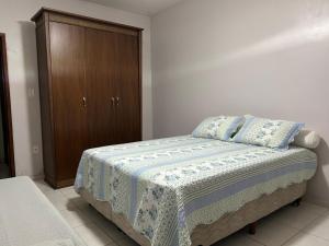 a bedroom with a bed and a wooden cabinet at Recanto do Ipês in Garanhuns