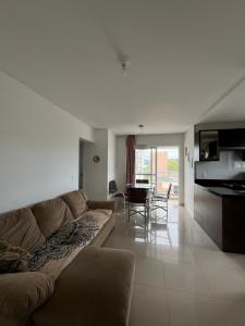 a living room with a couch and a dining room at Residencial Lunit in Camboriú