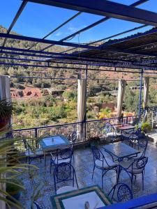 a patio with tables and chairs on a balcony at Kasbah Tifirte Grand Vallet in Ourika