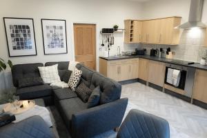 a living room with a couch and a kitchen at Lethbridge Villa 49 Apartment 2 Super Fibre WiFi, free parking in Southport