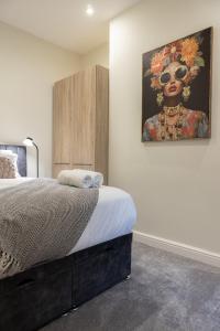 a bedroom with a bed with a painting on the wall at Lethbridge Villa 49 Apartment 2 Super Fibre WiFi, free parking in Southport