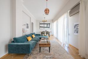 a living room with a blue couch and a table at Spacious 2BDs Apt With Acropolis View In Center in Athens