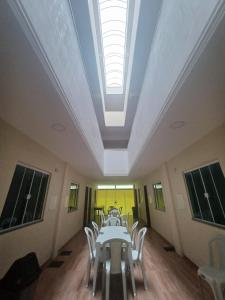 a room with a table and chairs and a skylight at Pousada Estrela Mares 101 in Cabo Frio