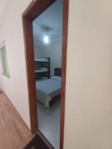 a mirror reflecting a bedroom with a bed in a room at Pousada Estrela Mares 101 in Cabo Frio