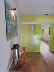a room with green walls and a counter with a coffee maker at Pousada Estrela Mares 101 in Cabo Frio