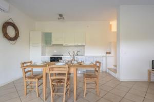 a kitchen with a wooden table and chairs at Elegant Residence Ea Bianca 2 Bedroom sleeps 6 plus extra bed available in Cala Bitta