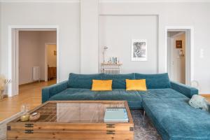 a living room with a blue couch and a coffee table at Spacious 2BDs Apt With Acropolis View In Center in Athens