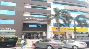 two cars parked in front of a building with palm trees at Suite en edificio Samborondon in SamborondÃ³n