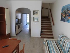 a living room with a staircase and a dining table at Cozy villa with private garden-Beahost in Porto Santa Margherita di Caorle
