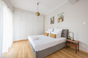 a bedroom with a large bed with white walls at Spacious 2BDs Apt With Acropolis View In Center in Athens