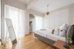 a white bedroom with a bed and a mirror at Spacious 2BDs Apt With Acropolis View In Center in Athens