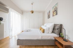 a white bedroom with a bed with white pillows at Spacious 2BDs Apt With Acropolis View In Center in Athens