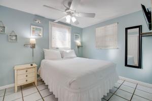 Un dormitorio con una cama blanca y paredes azules. en Duval Hideaway, en Key West
