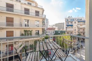 a balcony with a wooden table and two chairs at Spacious 2BDs Apt With Acropolis View In Center in Athens