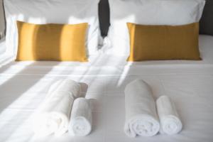 a white bed with three rolled up towels on it at Spacious 2BDs Apt With Acropolis View In Center in Athens