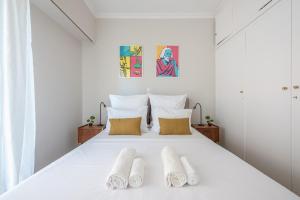 a bedroom with a white bed with two pillows at Spacious 2BDs Apt With Acropolis View In Center in Athens