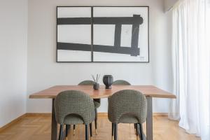 a dining room table with chairs and a picture on the wall at Spacious 2BDs Apt With Acropolis View In Center in Athens