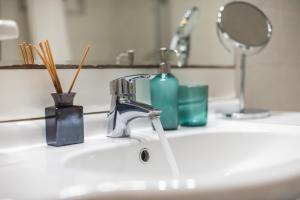 a bathroom sink with a faucet and a mirror at Spacious 2BDs Apt With Acropolis View In Center in Athens