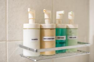a shelf in a bathroom with four bottles of soap at Spacious 2BDs Apt With Acropolis View In Center in Athens