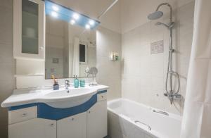 a bathroom with a sink and a tub and a shower at Spacious 2BDs Apt With Acropolis View In Center in Athens