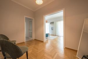 an empty living room with a chair and an open door at Spacious 2BDs Apt With Acropolis View In Center in Athens