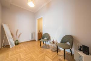 a living room with two chairs and a table at Spacious 2BDs Apt With Acropolis View In Center in Athens