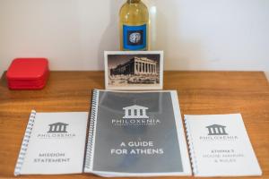 three books on a table with a bottle of wine at Spacious 2BDs Apt With Acropolis View In Center in Athens