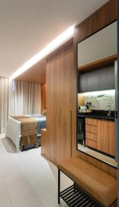 Pokój hotelowy z telewizorem i łóżkiem w obiekcie Loft com hidromassagem frente mar e pé na areia w mieście João Pessoa