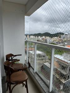 a chair sitting on a balcony with a view at Residencial Lunit in Camboriú
