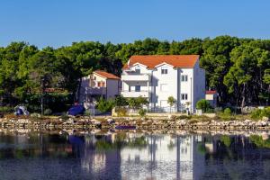 a large house on the shore of a body of water at Apartments Maras in Šibenik