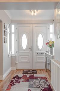 a white door with two windows and a rug at Room in Guest room - Apple House Wembley Twin Room in Edgware +2 photos