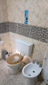 a bathroom with a toilet with a dirty seat at Complejo Arenas in Pehuén-Có