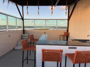 Zimmer mit einer Theke, Stühlen und einem WC in der Unterkunft Eco Miragem Residence - Porto de Galinhas in Porto De Galinhas